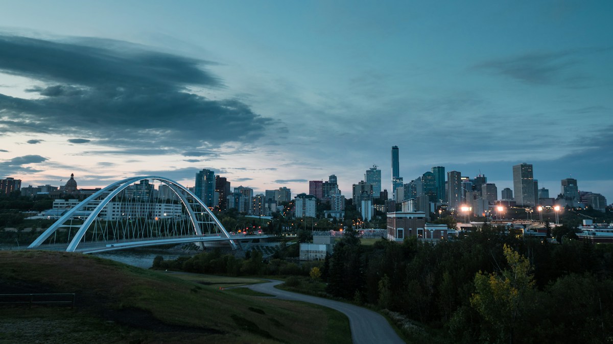 A white bridge and the Edmonton skyline at dusk.